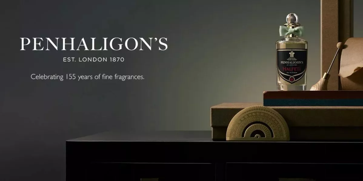 This is brand banner for Penhaligon's showing a fragrance bottle on a wooden table